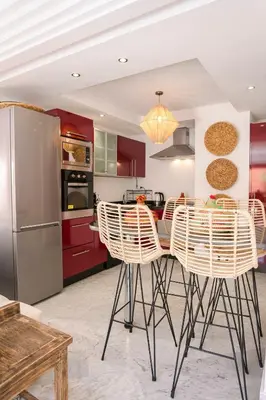 a kitchen with red cabinets and a table with chairs at Gueliz's Sun Marrakesh Centre in Marrakech