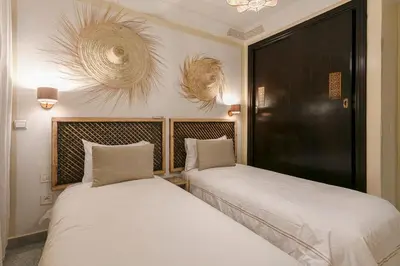 two beds sitting next to each other in a room at Gueliz's Sun Marrakesh Centre in Marrakech