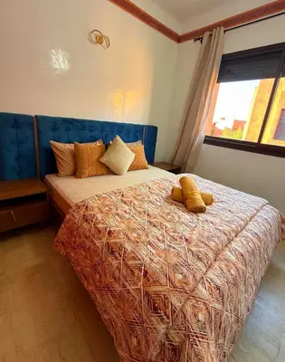 a bedroom with a large bed with pillows on it at Appartement Belle vue sur l'atlas in Marrakech