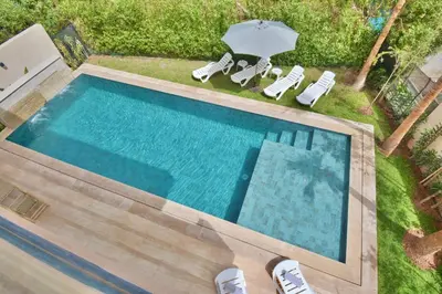 an overhead view of a swimming pool with chairs and an umbrella at Villa Luxe 5 Suites & Piscine in Marrakech