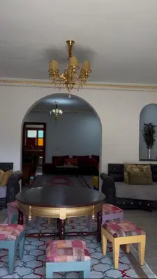 a living room with a table and a couch at Riad For families and groups in Marrakech
