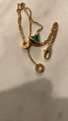 a gold necklace with a green jewel on a chain at Marrakech Bassatine targa in Marrakech