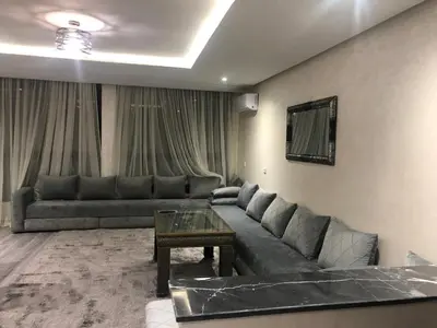 a living room with a couch and a table at APPARTEMENT MODERNE AU CENTRE m in Marrakech