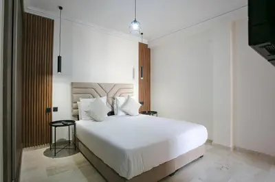 a bedroom with a large white bed and a television at Signature Suite Private Pool in Marrakech
