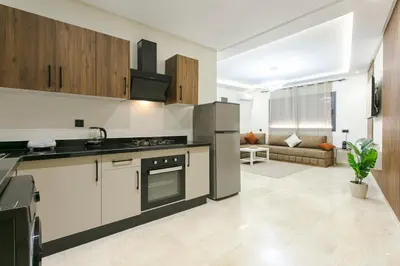 a kitchen with a stove top oven next to a living room at Signature Suite Private Pool in Marrakech