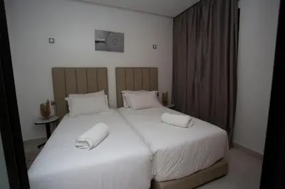 a bedroom with two beds with white sheets and pillows at Smart Loft in Marrakech