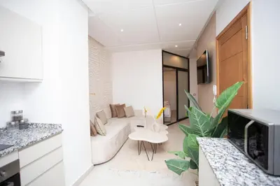 a kitchen and living room with a couch and a table at Smart Loft in Marrakech