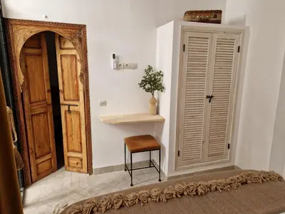 a room with a door and a chair and a table at Dar Baraï in Marrakech