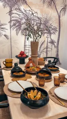 a wooden table with plates of food on it at Dar Baraï in Marrakech
