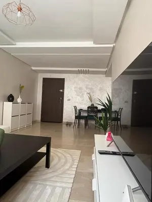 a living room with a table and a dining room at Appartement Vue sur piscine in Marrakech