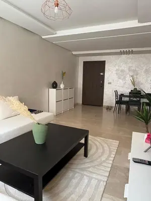 a living room with a couch and a table at Appartement Vue sur piscine in Marrakech
