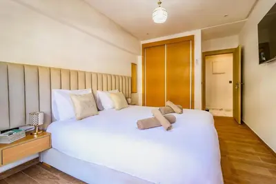 a bedroom with a white bed with two teddy bears on it at Piscine- Résidence haut de Gamme in Marrakech