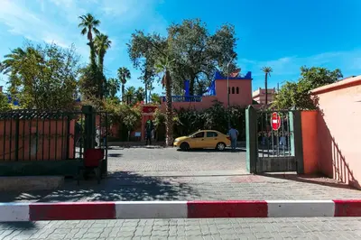 a gate to a parking lot with a yellow car at Majorelle Retreat in Marrakech