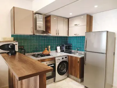 a kitchen with a refrigerator and a dishwasher at Stylish Apartment with Pool in Central Location Near Gueliz and Medina in Marrakech