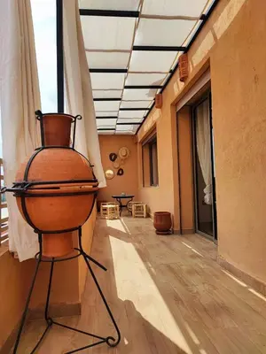 a room with a chair and a table in a building at Stylish Apartment with Pool in Central Location Near Gueliz and Medina in Marrakech