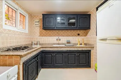 a kitchen with black cabinets and a sink at Riad Zitoune in Marrakech
