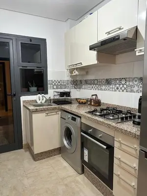 a kitchen with a stove and a washing machine at Luxury apartment and free parking in Marrakech