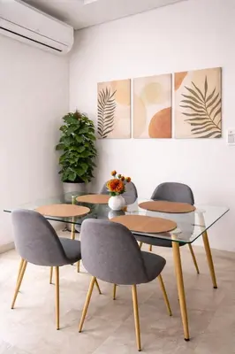 a dining room with four chairs and a glass table at Luxury apartment and free parking in Marrakech