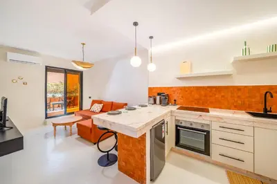 a kitchen with a counter top and a living room at Exclusive Family Appartement in Marrakech