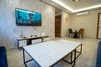 a living room with a tv on a wall at Luxury 2-Bedroom Apartment with Balcony - Heart of Gueliz in Marrakech
