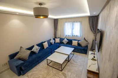 a living room with a blue couch and a table at Luxury 2-Bedroom Apartment with Balcony - Heart of Gueliz in Marrakech