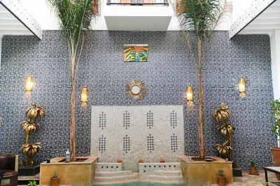 a room with palm trees and a tile wall at Riad Dar Mima Hnina - Your Traditional and Private haven of peace, 2 pools, 10' from airport in Marrakech