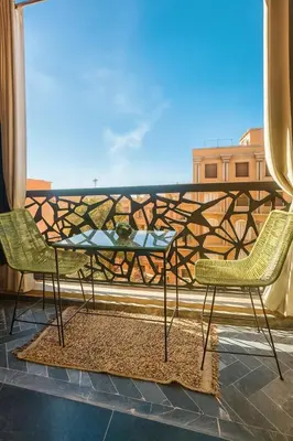 a table and chairs on a balcony with a view at Chic 1 bedroom WiFi apartment Marrakech in Marrakech