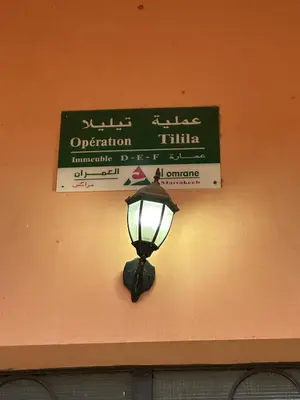 a street light attached to a wall with a sign at Elegant 2 Bedrooms with Pool & Wi-Fi Marrakech in Marrakech