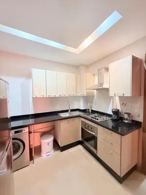 a kitchen with white cabinets and a black counter top at A21 Moderne Confort Au Cœur De Marrakech in Marrakech