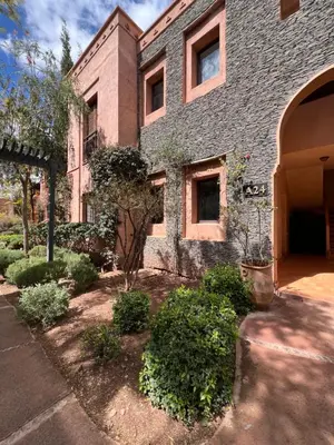 a large brick building with trees and bushes in front of it at Resort Apartment Golf View in Marrakech