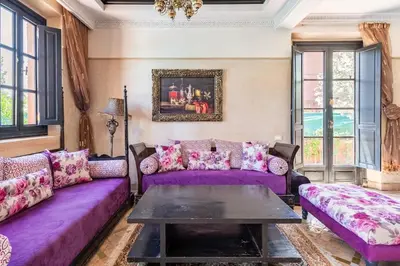 a living room with purple couches and a table at Beautiful villa with a private pool in La Palmeraie neighborhood in Marrakech
