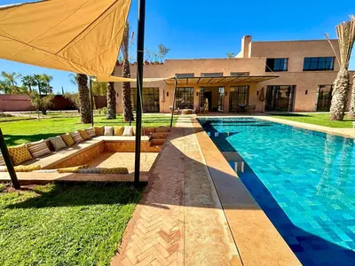 a house with a swimming pool and an umbrella at Palais Kenza in Marrakech