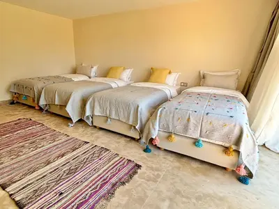 two beds sitting in a room with a room with rugs at Palais Kenza in Marrakech