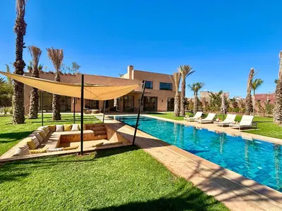 a swimming pool with a tent and chairs next to a house at Palais Kenza in Marrakech