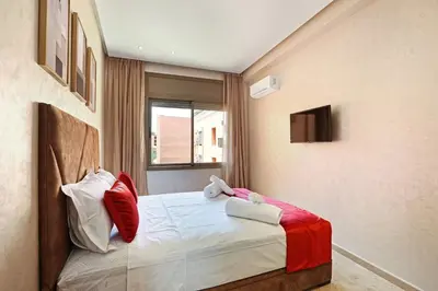 a bedroom with a bed with red and white pillows at New Elegant and cozy appartement next to carre eden in Marrakech