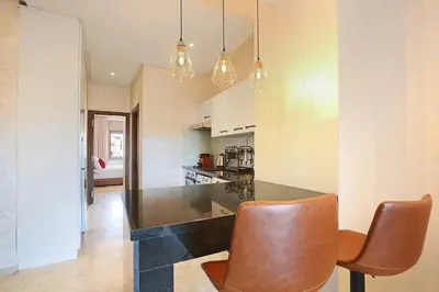 a kitchen with a black counter and brown chairs at New Elegant and cozy appartement next to carre eden in Marrakech