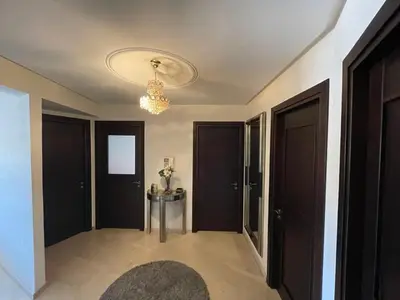 a hallway with black doors and a chandelier at Apartement de Luxe mit Tiefgarage in Marrakech