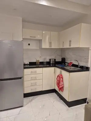 a kitchen with white cabinets and a stainless steel refrigerator at Elegant & Comfortable Apartment in Marrakesh in Marrakech