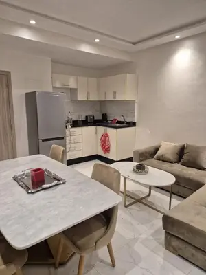 a kitchen and living room with a table and a couch at Elegant & Comfortable Apartment in Marrakesh in Marrakech