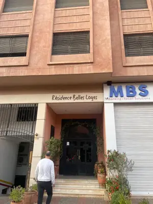a man walking into the front of a building at Appartement luxueux Gueliz in Marrakech