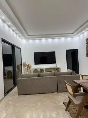 a living room with a couch and a flat screen tv at Appartement luxueux Gueliz in Marrakech