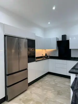 a kitchen with white cabinets and a stainless steel refrigerator at Appartement luxueux Gueliz in Marrakech