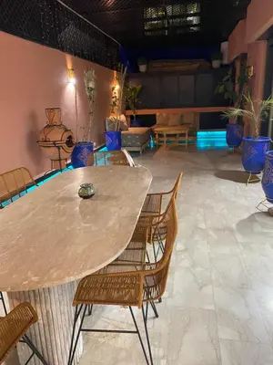 a table and chairs in a room with plants at Appartement luxueux Gueliz in Marrakech