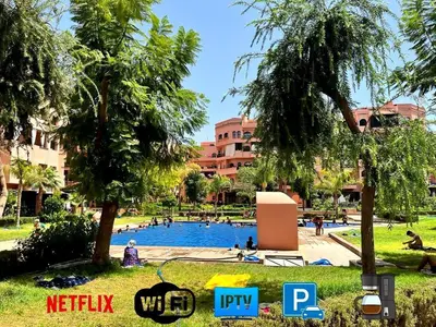a swimming pool in a park with palm trees at Luxury Apartment in Marrakech Premium Village 5 Pools free Parking in Marrakech