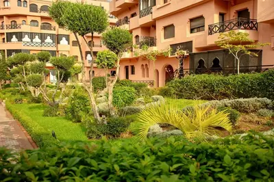 a garden in front of a large building at Luxury Apartment in Marrakech Premium Village 5 Pools free Parking in Marrakech