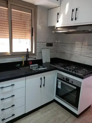 a kitchen with white cabinets and a stove top oven at Cozy with Moroccan flair in Marrakech