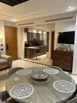 a living room with a table and a kitchen at Appartement le vizir center in Dar Caïd Layadi