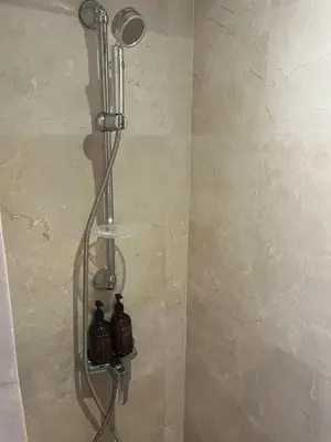 a shower with two bottles on a wall at Appartement le vizir center in Dar Caïd Layadi