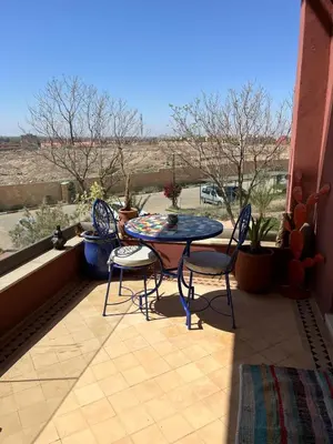 a patio with a table and chairs on a balcony at Appartement le vizir center in Dar Caïd Layadi