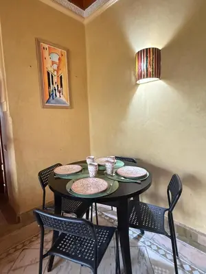 a dining room table with chairs and a table with plates at 2 bedroom palmeraie, pools & 3 terraces in Marrakech